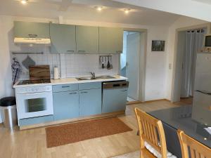 a kitchen with blue cabinets and a counter top at Ferienwohnungen Binder in Mauth +12 photos
