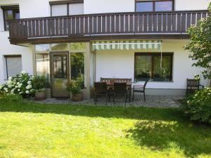 a patio with a table and chairs in front of a house at Ferienwohnungen Binder in Mauth