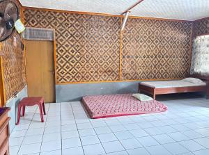 een kamer met een bed, een tafel en een stoel bij Pondok Galang in Pangandaran