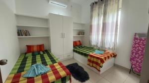 two twin beds in a room with a window at Cozy Clifford Homagama in Homagama +7 photos