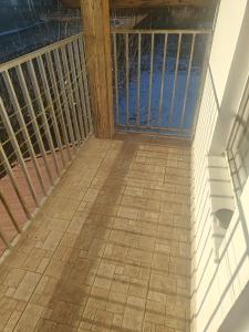 een balkon met een houten leuning en een tegelvloer bij Vila Ekooos in Braşov