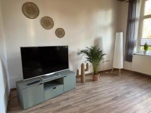 un salon avec une grande télévision à écran plat dans l'établissement NEU! Ferienwohnung Zwei Linden, à Uthlede