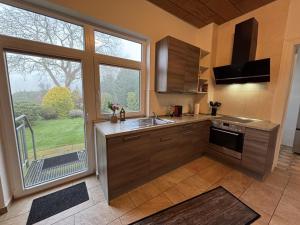une cuisine avec un évier et une grande fenêtre dans l'établissement NEU! Ferienwohnung Zwei Linden, à Uthlede