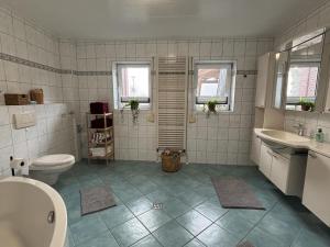 une salle de bains avec toilettes, baignoire et lavabo dans l'établissement NEU! Ferienwohnung Zwei Linden, à Uthlede 5 autres photos