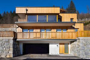 a house with a garage in front of it at Alpen-Chalet mit privater Sauna und Gletscher Panorama in Neukirchen am Großvenediger