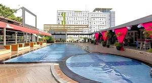 einem großen Pool an der Seite eines Gebäudes in der Unterkunft Horison Ultima Makassar in Makassar