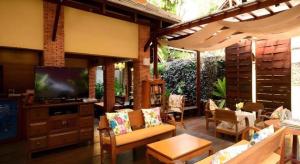 een woonkamer met stoelen en een televisie op een terras bij Baan Talay Dao Resort in Hua Hin