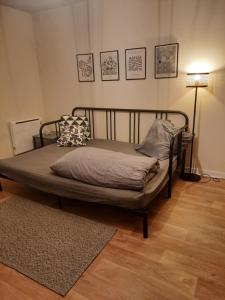a bed in a room with a lamp and a rug at Studio agréable dans résidence in Joué-lès-Tours