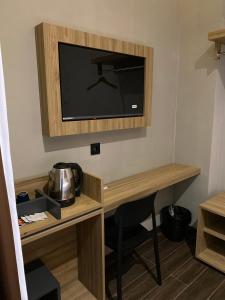 una camera con scrivania e TV appesa a un muro di Moonstone a Bandung Altre 15 foto