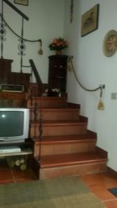 a room with a staircase with a television and a stair case at La Montanara Apartment in Castel di Sangro