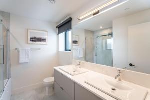 a white bathroom with a sink and a mirror at Qs Hideaway in Mackenzie Village in Revelstoke +20 photos