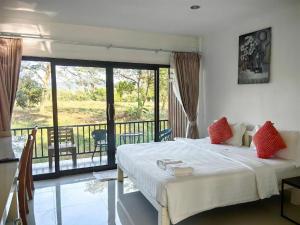 une chambre avec un grand lit et un balcon dans l'établissement De Bua Valley, à Ban Kom 152 autres photos