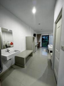 une salle de bains blanche avec un lavabo et un miroir dans l'établissement De Bua Valley, à Ban Kom