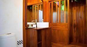 ein Badezimmer mit einer Holztür und einem Waschbecken in der Unterkunft Srisawat Resort in Cha-am + 156 Fotos