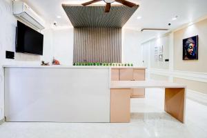 een lobby met een witte balie en een televisie bij Townhouse Oak Ram Lala Mandir Kanpur Formerly Hotel Sun Rise in Kaliānpur