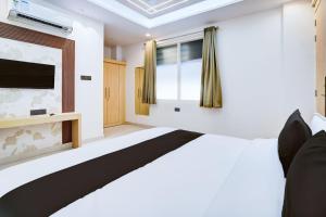 een slaapkamer met een bed en een flatscreen-tv bij Townhouse Oak Ram Lala Mandir Kanpur Formerly Hotel Sun Rise in Kaliānpur