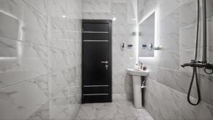 bagno con porta nera e lavandino di Distinct Apartment a Adeleye Altre 10 foto