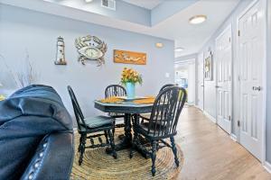 una sala da pranzo con tavolo, sedie e divano di Hook, Wine, & Linger condo a Destin