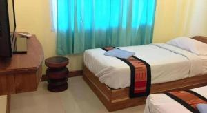 une chambre avec deux lits, un bureau et une télévision dans l'établissement Lankham Hotel, à Pakse 57 autres photos