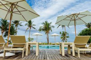 een terras met stoelen en parasols naast een zwembad bij Isla Cabana Resort in General Luna