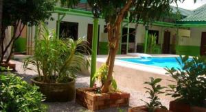 een huis met een zwembad en een aantal planten bij Nayai Resort in Chalong 