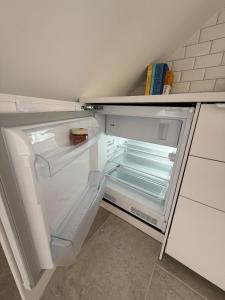 an empty refrigerator with its door open in a kitchen at Wunderschöne Wohnung direkt am St Johanner Markt in Saarbrücken