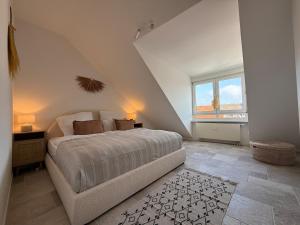 a bedroom with a bed and a large window at Wunderschöne Wohnung direkt am St Johanner Markt in Saarbrücken