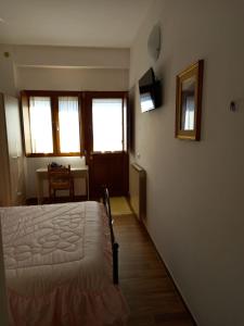 een slaapkamer met een bed, een tafel en ramen bij La Casa di Rossella - pernottamento senza colazione in Scanno