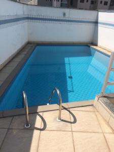 uma piscina com dois carris de metal à volta em Apart Quartier Latin Hotel em Vitória