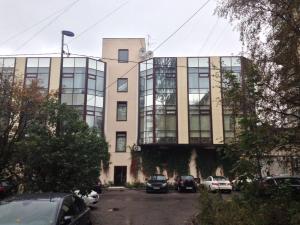 duży budynek z samochodami zaparkowanymi na parkingu w obiekcie Hotel Silk Way w Petersburgu