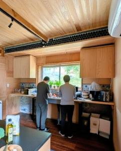 twee mensen aan een aanrecht in een keuken bij Kaido Nomad CoLiving in Yuzawa