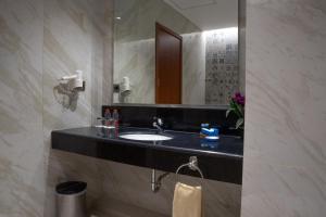 a bathroom with a sink and a mirror at Hotel Brothers Solo in Solo