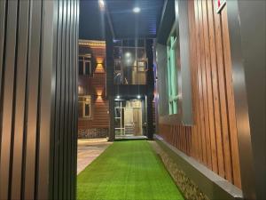 a hallway with a green floor in front of a building at The Routes Pahalgam in Kolur +9 photos