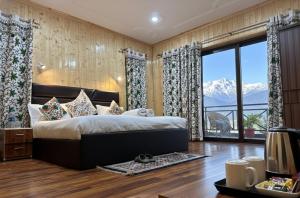 a bedroom with a bed with a view of a mountain at The Routes Pahalgam in Kolur