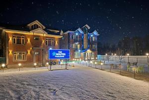 a house with a sign in front of it in the snow at The Routes Pahalgam in Kolur