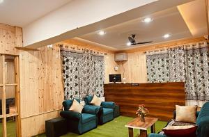 a living room with wooden paneling and blue furniture at The Routes Pahalgam in Kolur