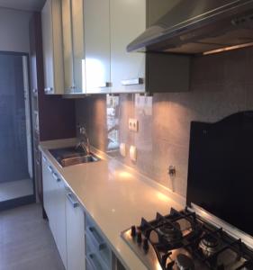 uma cozinha com um fogão e armários brancos em Sea and Marina view Apartment em Setúbal