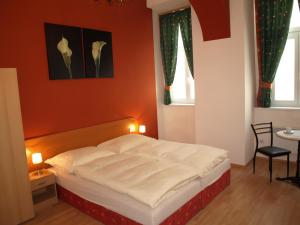 a bedroom with a bed with an orange wall at Pension Tal Studios in Vienna