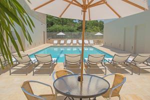 a table with an umbrella next to a swimming pool at Hotel San German in Girardot
