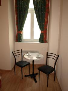 a table and two chairs in a room with a window at Pension Tal Studios in Vienna