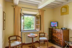 um quarto com duas cadeiras, uma mesa e uma janela em Casa Portagioia em Castiglion Fiorentino