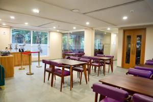 a waiting room with tables and purple chairs at Hotel Hanata Kochi in Cochin +61 photos