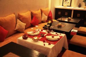 a living room with a table and a couch at Riad Diana in Marrakesh