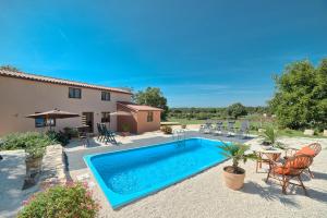 basen przed domem z krzesłami i stołem w obiekcie Beautiful villa Palera with private pool near Pula w mieście Ližnjan