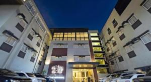 a building with cars parked in front of it at Eighty Eight Hotel in Koronadal