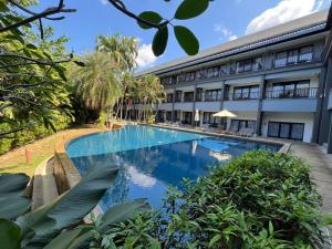 een extern uitzicht op een hotel met een zwembad bij Khao Lak - Loft Suite with 2 king size beds, bathroom with bathtub in Khao Lak