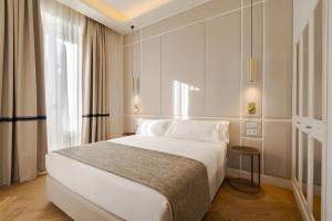 ein Schlafzimmer mit einem weißen Bett und einem Fenster in der Unterkunft La Fonda de los Principes in Madrid
