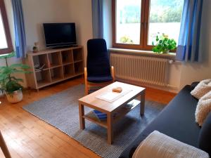 a living room with a couch and a coffee table at Ferienwohnung Eckschlager in Kössen