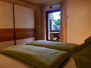 a bedroom with two beds and a window at Ferienwohnung Eckschlager in Kössen