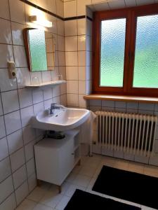a bathroom with a sink and a mirror and a window at Ferienwohnung Eckschlager in Kössen +35 photos